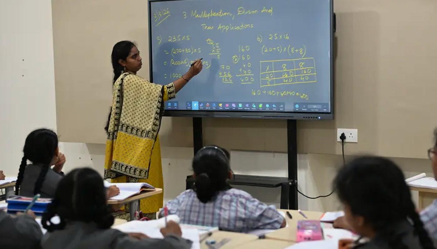 Look at how lessons are taught during a school visit Teacher explaining a concept on an interactive panel to a class of students