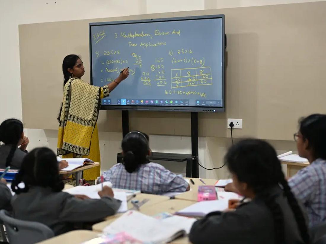 Teacher explaining a concept on the interactive smart board to a class