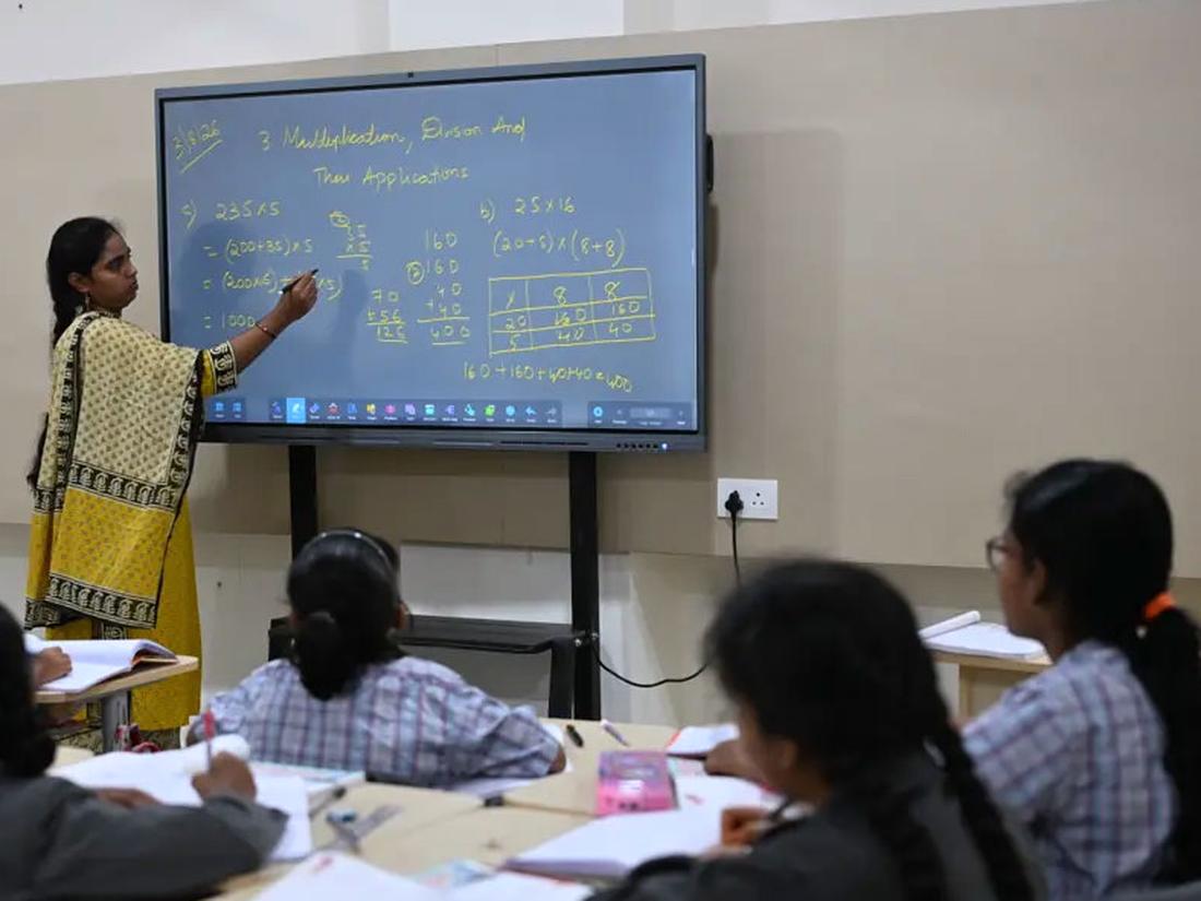 Teacher using the smart board during a primary lesson