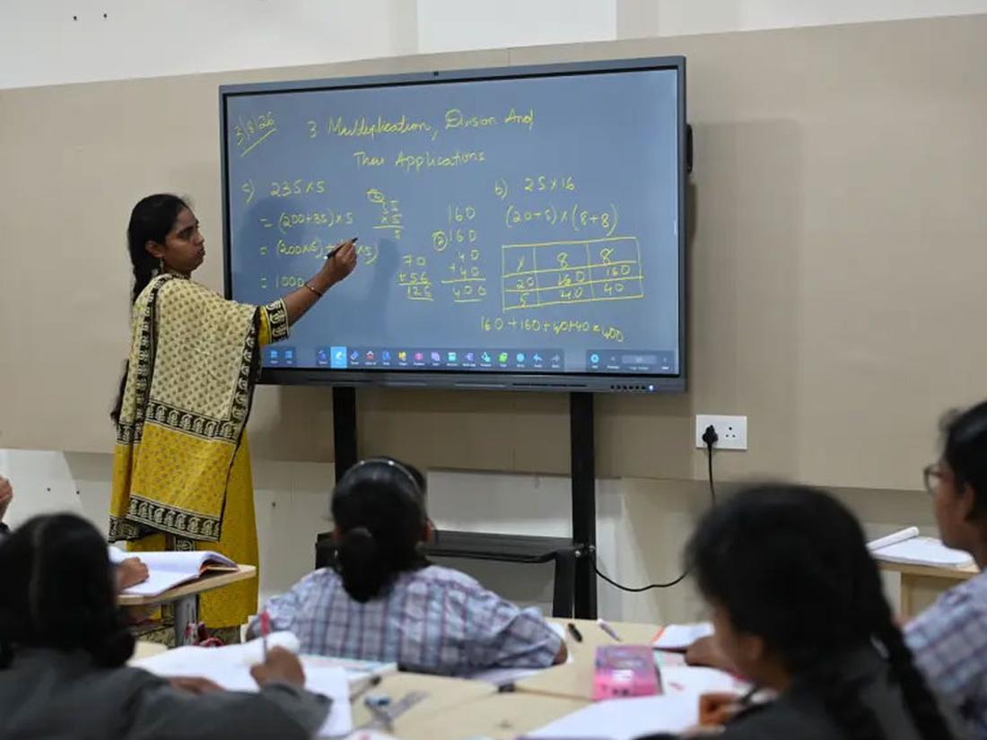 Teacher modelling a worked example on the smart board for students