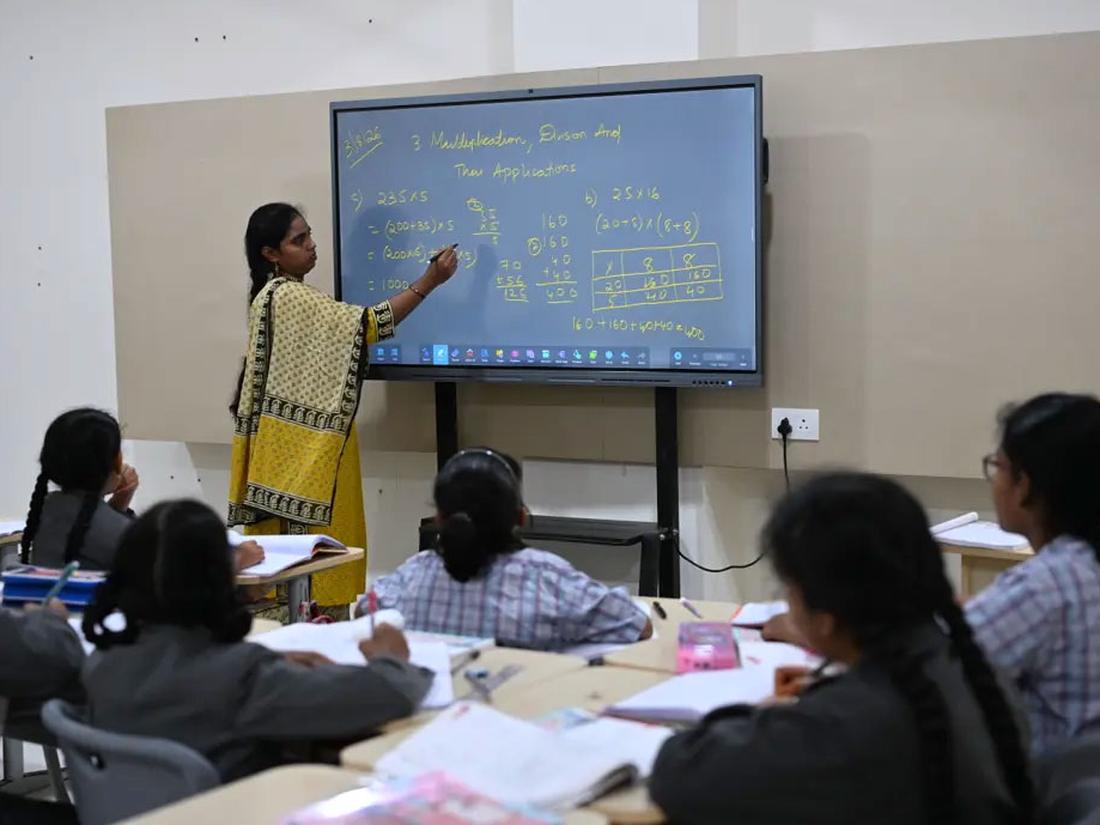 Teacher guiding students through a lesson on the smart board