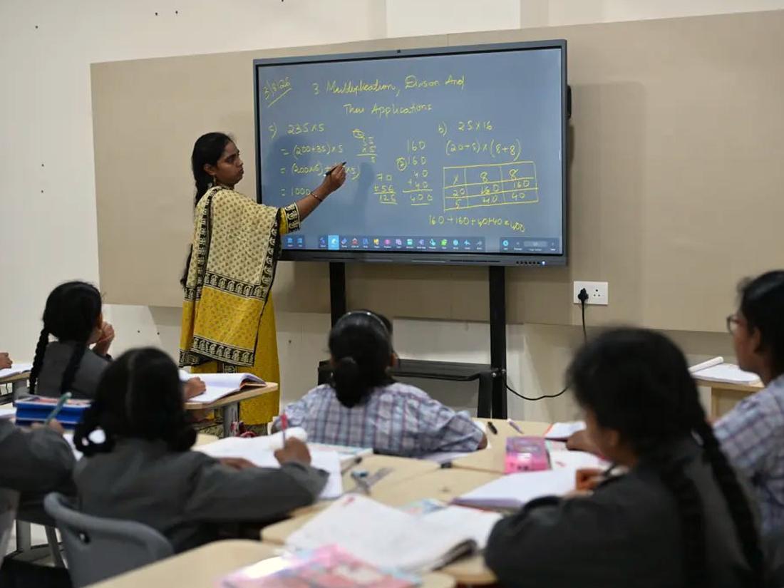Teacher explaining a lesson on an interactive panel to middle school students Teacher explaining a lesson on an interactive panel to middle school students